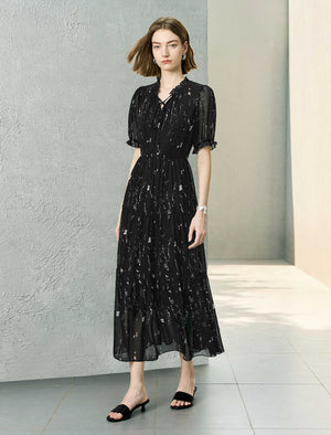 Woman wearing a black dress with white patterns in an indoor setting